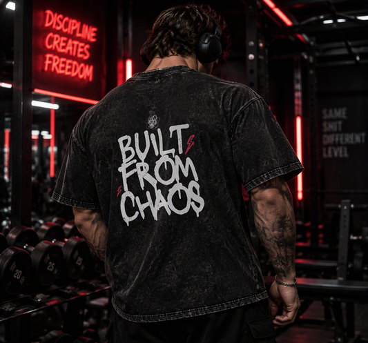 Built From Chaos oversized tee – man showing the Built From Chaos back print in a red neon gym, AI-generated mockup