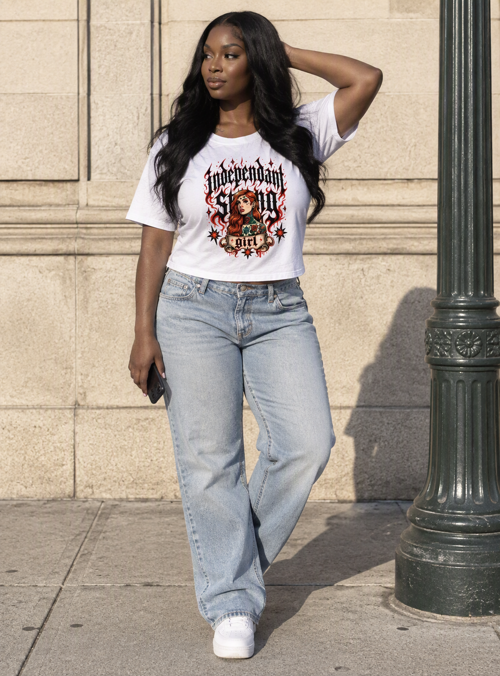 Independent Strong Girl baby tee – woman wearing the baby tee with jeans on a street, AI-generated mockup