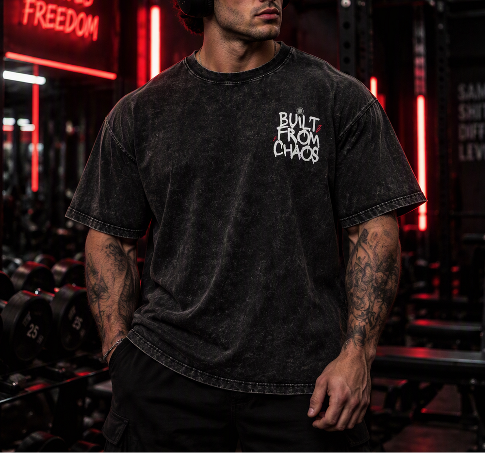 Built From Chaos oversized tee – man wearing the tee in a gym, front view, AI-generated mockup