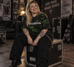 Wired Different women's oversized tee – woman wearing the tee, seated, AI-generated mockup